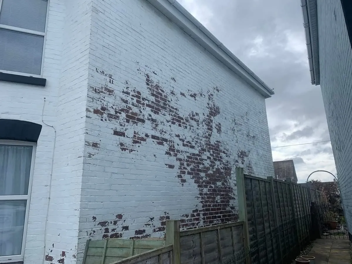 Peeling paint on a brick wall before redecoration in Brixham